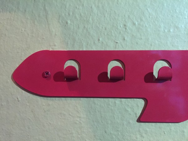 Close up kids coat rack airplane hooks red metal wall mounted rack