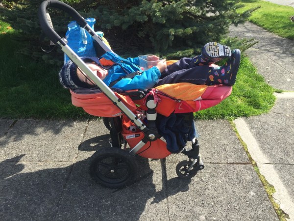 Child reclined in Bugaboo Frog stroller outside in sunshine