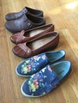 Slip on shoes lined up on floor from SeaVees Hush Puppies and Merrell