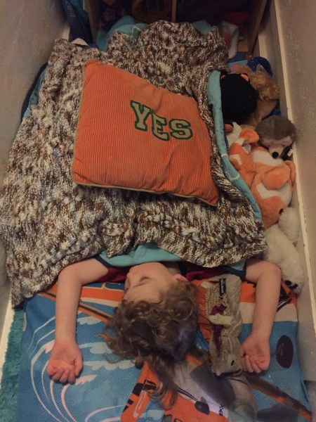 Four year old passed out sleeping on floor with pillows and blanket