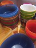 Stacks of brightly colored kids dishes cups and bowls