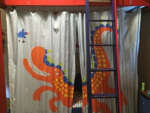 Curtain screen for lower bunk bed hanging behind ladder