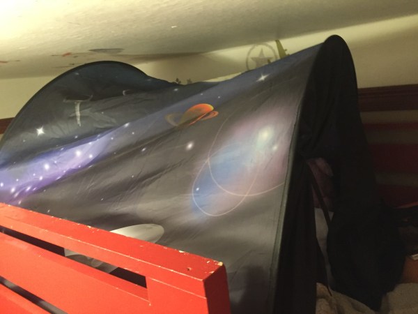 dream tent space theme installed in upper bunk near ceiling