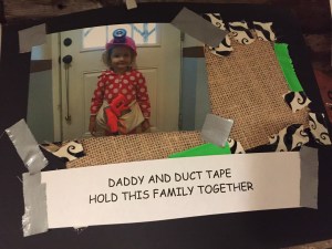 Child wearing hard hat in paper photo frame decorated with duct tape