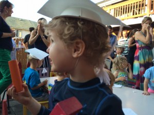 Child wearing graduation hat craft from bowl and cardboard at kids' party