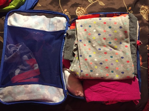 Clothes packed into open Eagle Creek pack it cube large with blue flower print