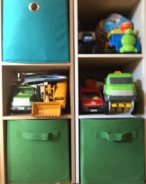 Toy vehicles stored on cube shelved and in bins