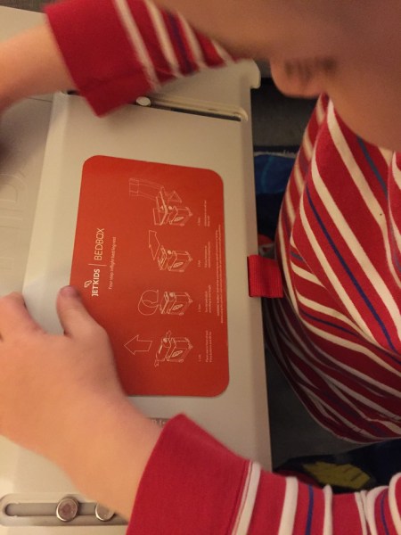 Child reading instructions printed on JetKids BedBox lid