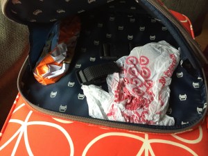 Plastic bag, luggage strap, and inflatable beach ball inside suitcase pocket