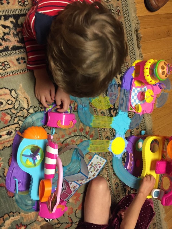 Kids playing with Zuru Hamsters in the House play sets combined into big city on floor rug
