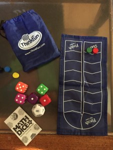 Math Dice game for kids by ThinkFun pieces laid out on glass coffee table top