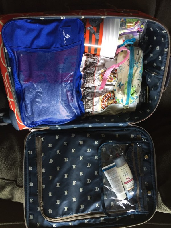 Carry on suitcase Orla Kiely packed with Eagle Creek Large pack it cube in blue and other miscellaneous items