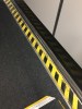 Side of jetway with black and yellow caution stripes on edges of floor