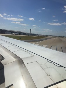 Control tower and runway behind plane wing