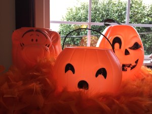 Plastic orange pumpkin buckets including one shaped like Tigger