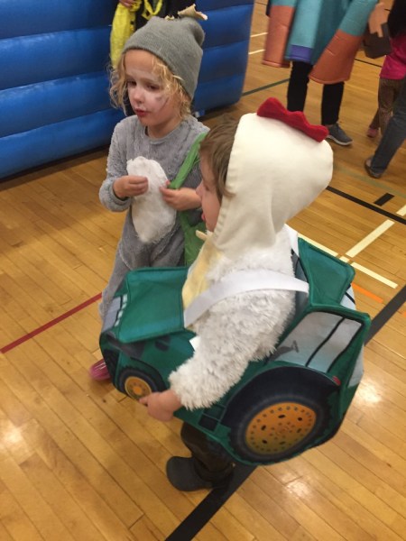 Two kids in Halloween costumes gray puppy dog and chicken in tractor