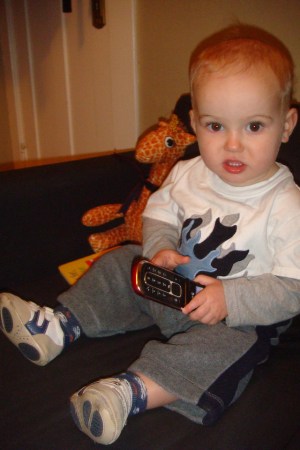 Child playing with old inactive flip phone