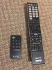 Sony and iHome remote controls laying on carpet