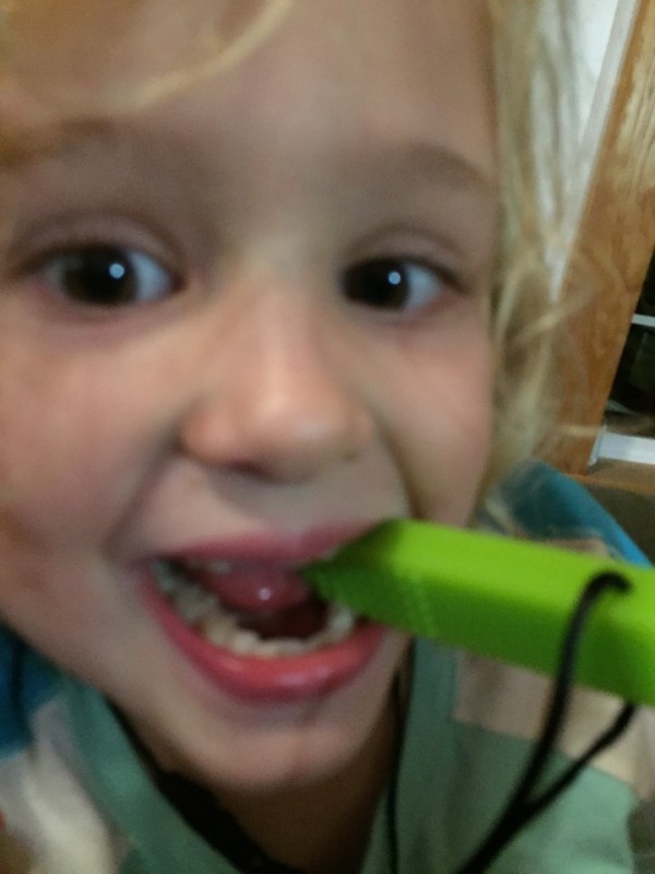 Child chewing on sensory necklace green brick shaped Chew-E-Chainz