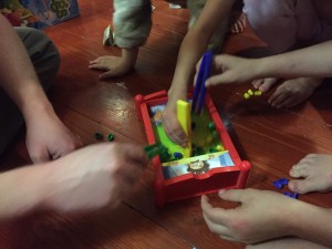 Kids and adult playing Bed Bugs game by Hasbro