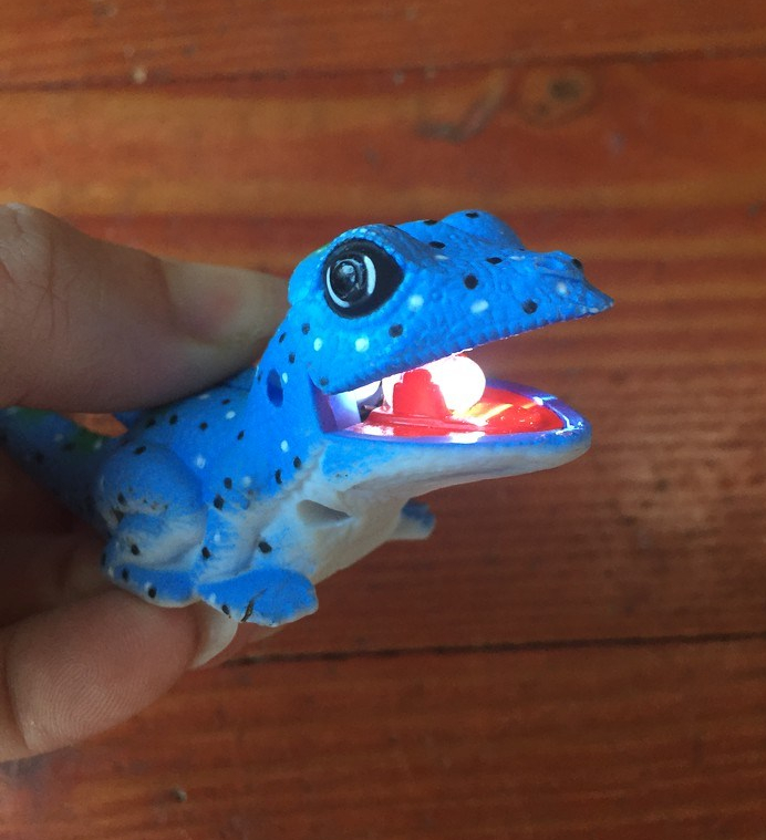 Blue lizard kids' animal flashlight with lightbulb in mouth lit up