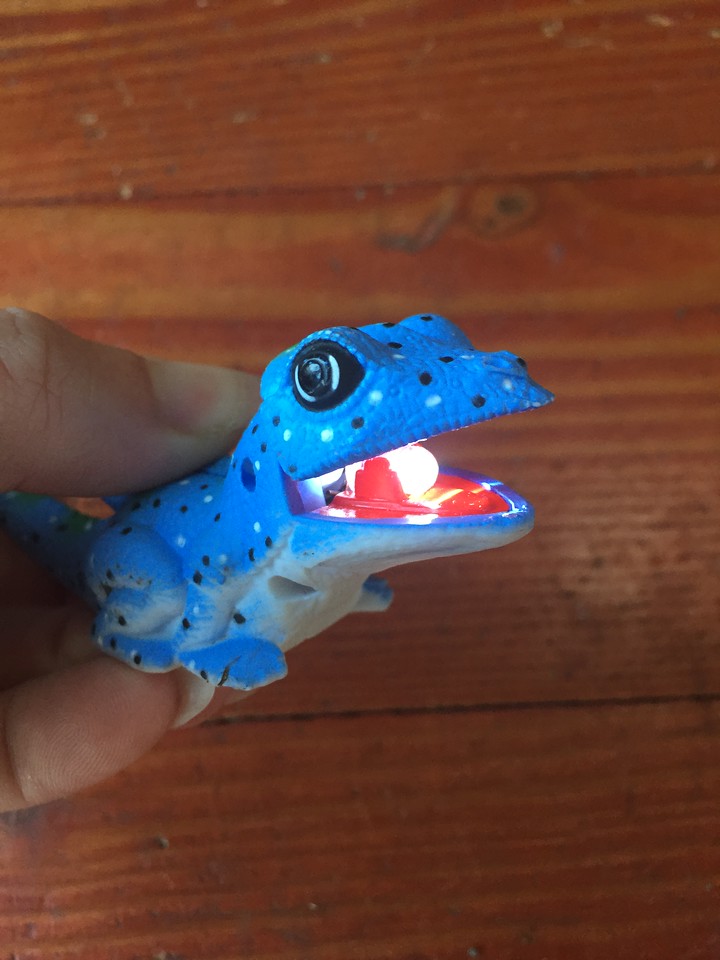 Blue lizard kids' animal flashlight with lightbulb in mouth lit up