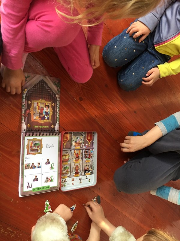 Four kids playing Logic Land The Enchanted Castle Deduction puzzle by Brainwright games
