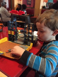 Child playing with Tonka Tinys Cityscape Carrying Case Playset at restaurant table
