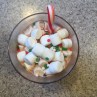 Holiday hot cocoa for kids with miniature candy cane stirrer mini marshmallows and red green and white sprinkles