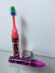 GUM Crayola kids travel toothbrush in red standing upright and pink in case laying down