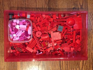 Red Legos sorted into red drawer from rainbow storage drawer with small container of pink Lego in middle