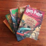 Harry Potter books stacked and fanned out paperback and hardback mixed volumes