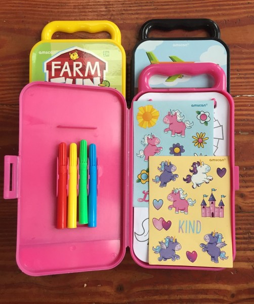Amscan travel coloring kits in yellow farm, black planes trains cars, and pink unicorn themes with mini markers, sticker sheets, and coloring sheets shown inside open case