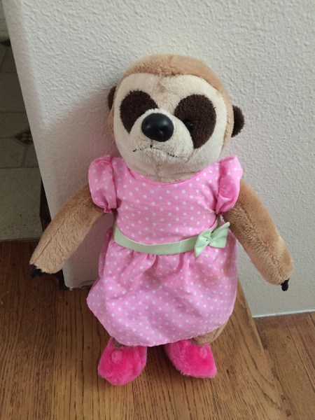 Meerkat stuffed animal in pink polka dot dress with pink fuzzy slippers