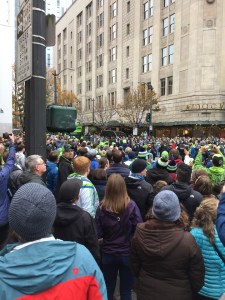 Crowd on busy street with tall buildings in background