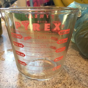 Glass pyrex measuring cup on kitchen cabinet