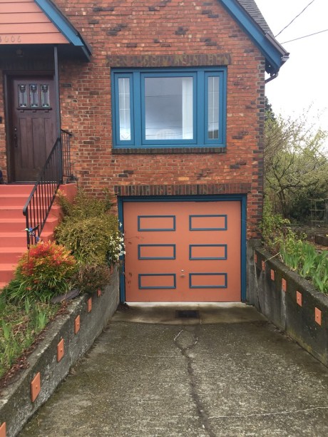 Brick Tudor house with blue window and garage door trim