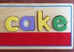 Melissa & Doug See and Spell word letter learning wooden learning toy cake puzzle board with lowercase letters filled in with pieces