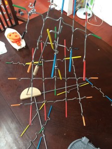 Melissa and Doug Suspend family game in middle of playing with colored rods suspending from one point
