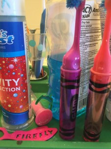 Kids' toothbrushes, toothpaste, flosser, timer, and mouthwash crowded together close up