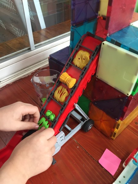 Playmobil country hay bale conveyor belt dropping food into Magna-Tile building