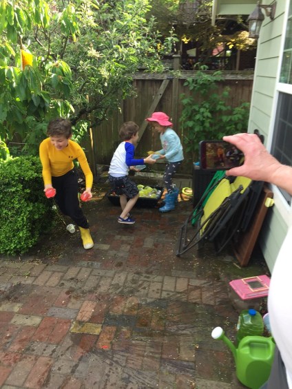 Kids playing with water balloons in yard