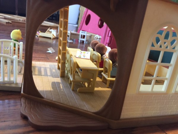 Doorway opening into Calico Critter Country Tree School with bears seated in first row of desks