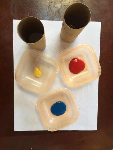Paint in food containers with paper and empty toilet tubes