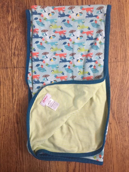 Zutano baby blanket with green and white stripes and orange and blue fox print on reverse side