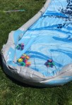 Homemade sponge bomb water balloon alternatives in inflatable pool with super saber soaker water gun in grass in the background