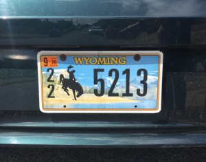 Wyoming license plate 2020 on car with bucking bronco pictured in front of mountains and river