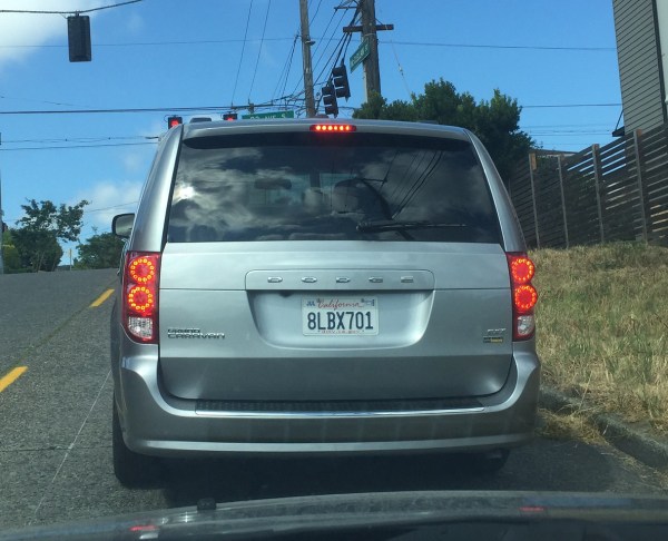 California license plate on minivan on city street
