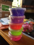 DIY Slime Kit six small brightly colored containers of slime stacked vertically on table