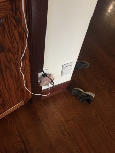 Sock draped over cords plugged into electrical outlet